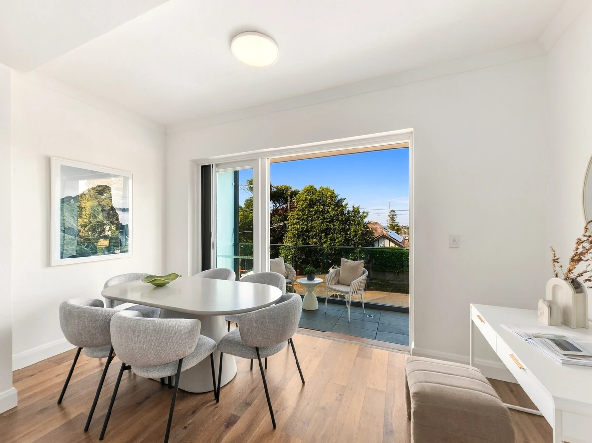 Finished Roomshot photo of a Bondi dining room opening onto a sunny balcony